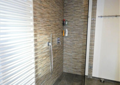 Theo Frommlet - Fugentechnik Memmingen - Glasttechnik im Sanitärbereich und Küchenbereich - Dusche mit Stein-Glasrückwand